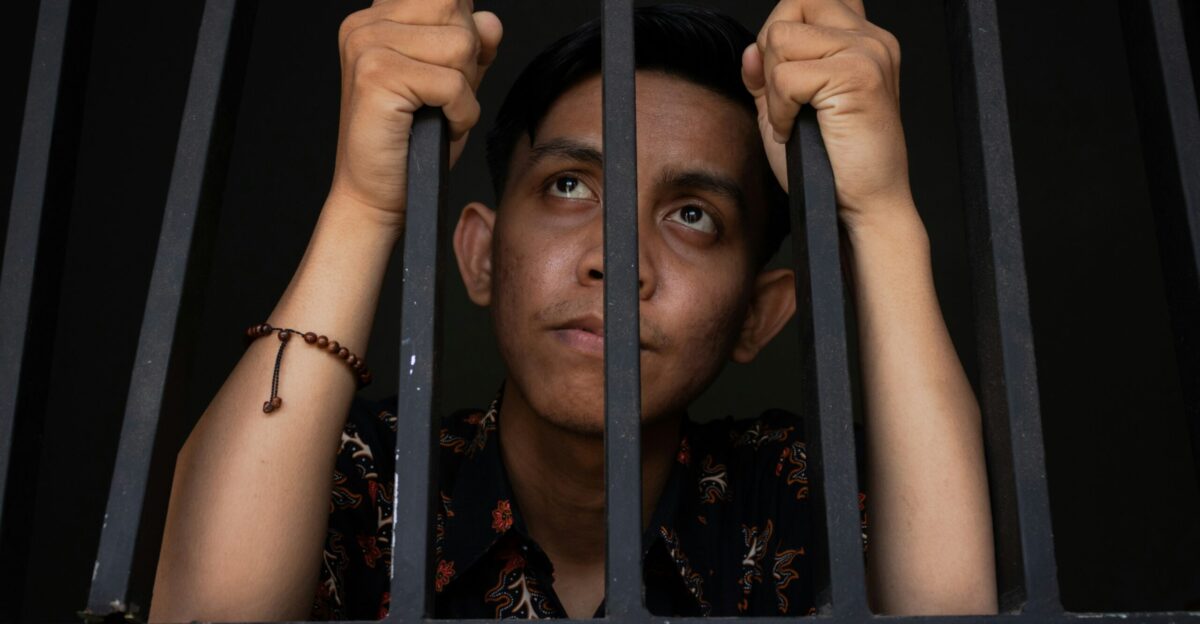 a man is looking out of a jail cell