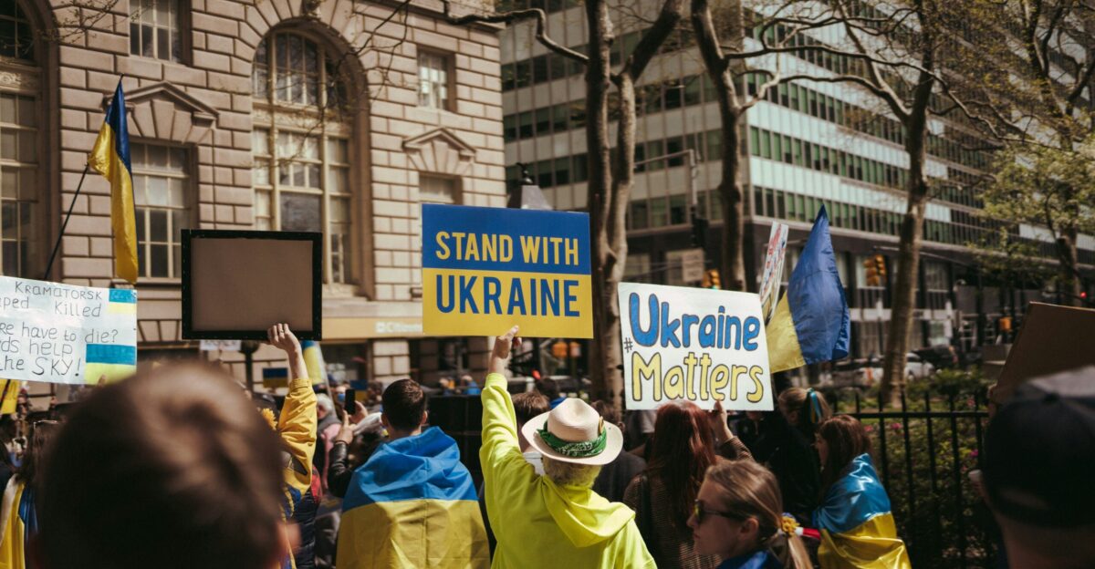 a group of people holding up signs in front of a building