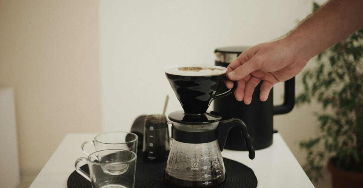 a person pours a cup of coffee from a coffee maker