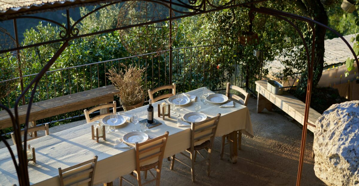 a table set up for a meal under a pergolated roof