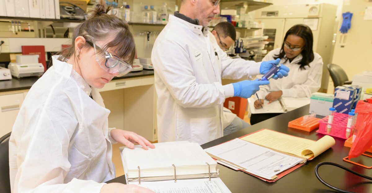 a group of people in lab coats working in a lab
