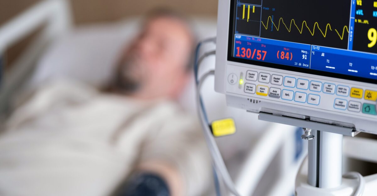 a man laying in a hospital bed next to a monitor