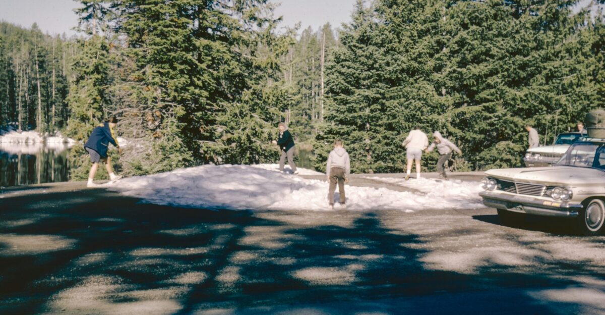 a group of people walking across a snow covered road
