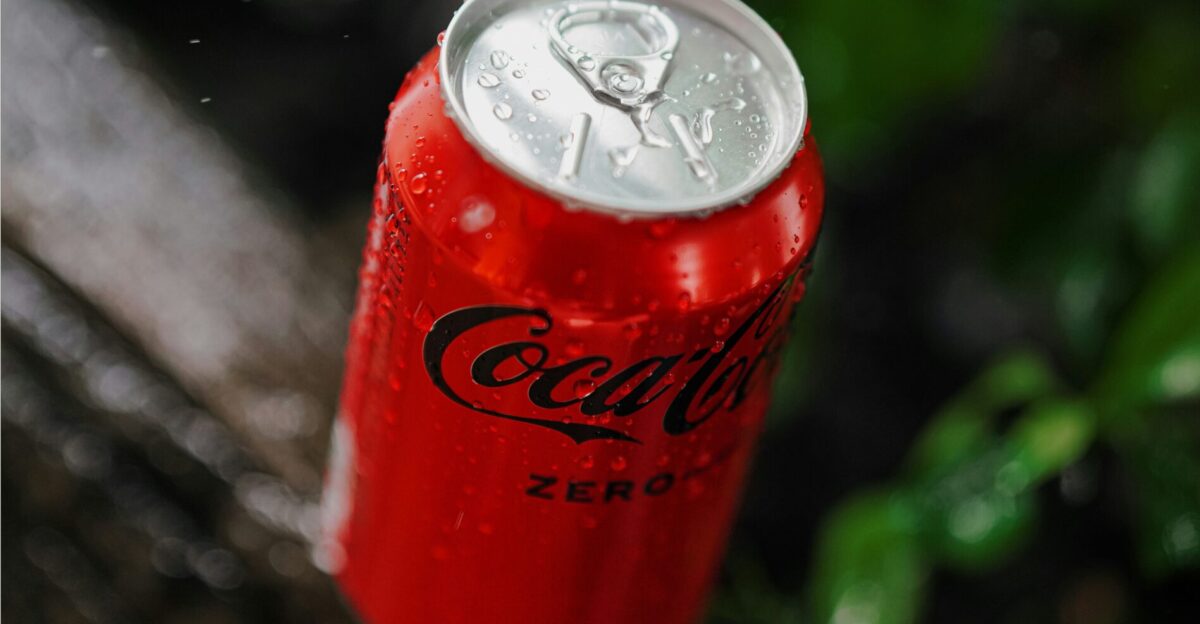 A can of coca - cola sitting on top of a wooden bench
