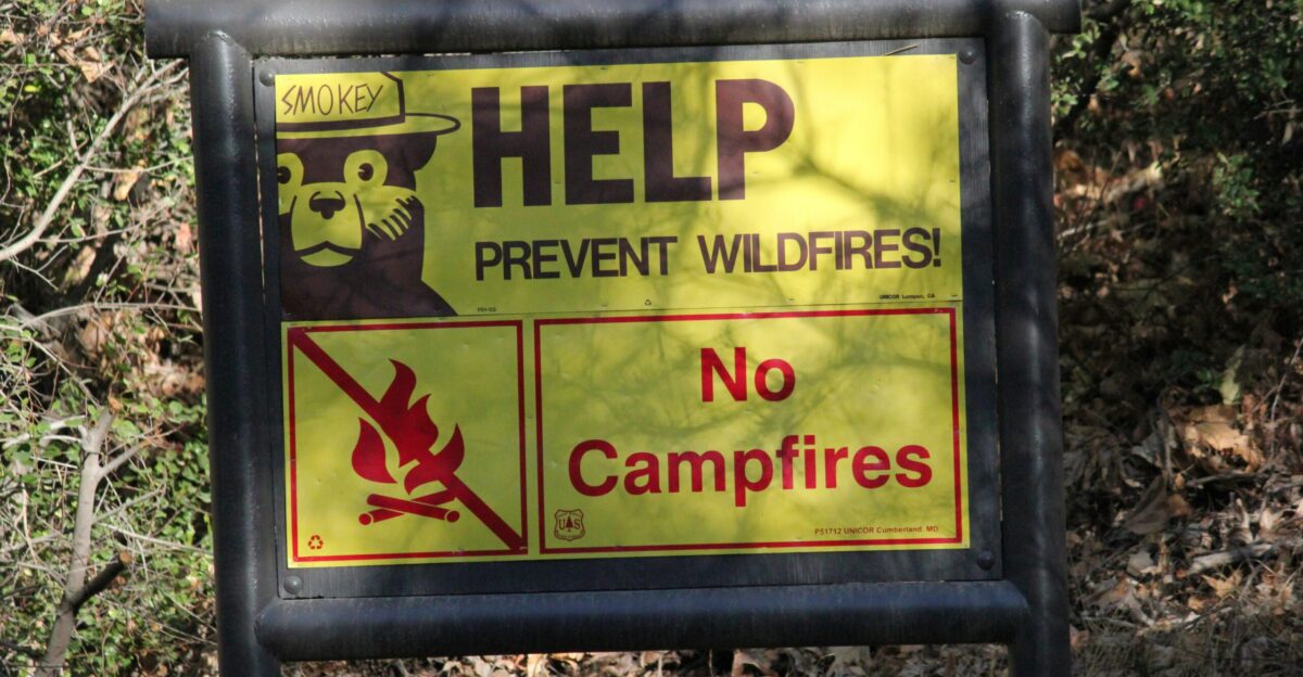 A sign that is in front of some trees
