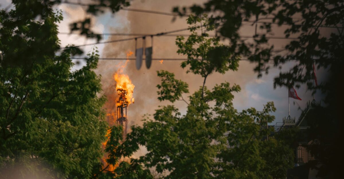 A pole is engulfed in flames with smoke