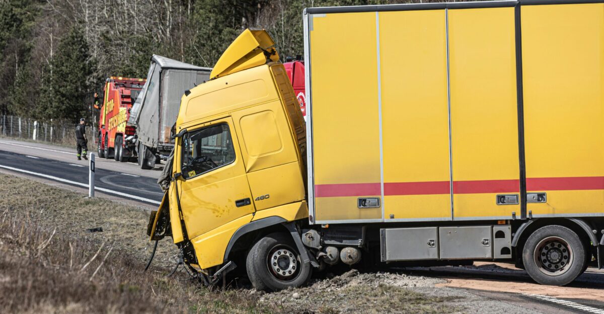 A yellow semi-truck is in a roadside accident