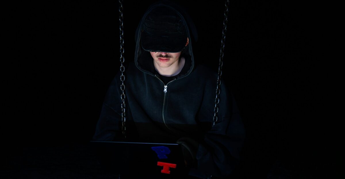 A figure is using a laptop in the dark
