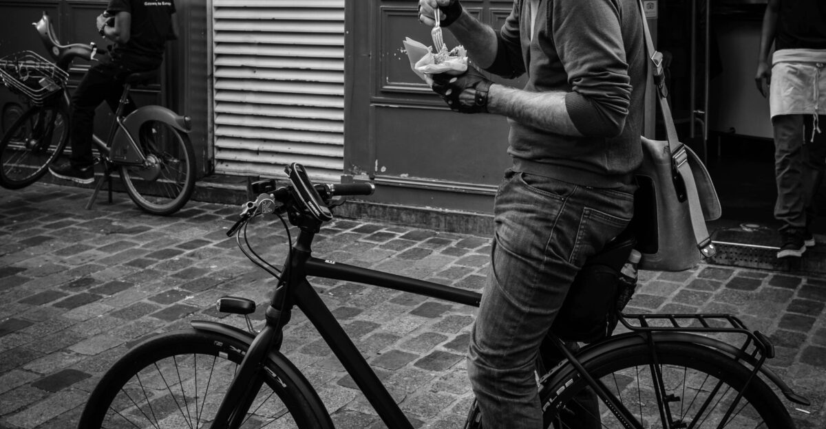 A man eating street food on his bike in Paris France