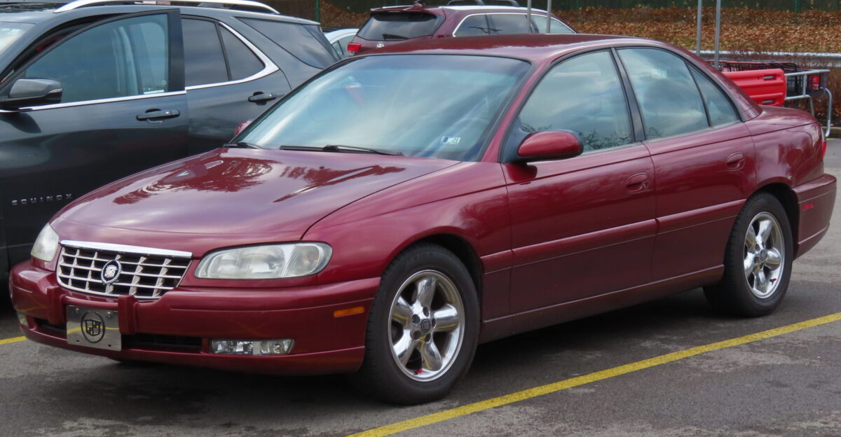 Cadillac Catera photographed in New Castle Pennsylvania Finished in Cranberry and fitted with the optional chrome 5-spoke rims I did not notice the person getting out of the Equinox next to it who I ve edited out and they did not ask anything before I walked away