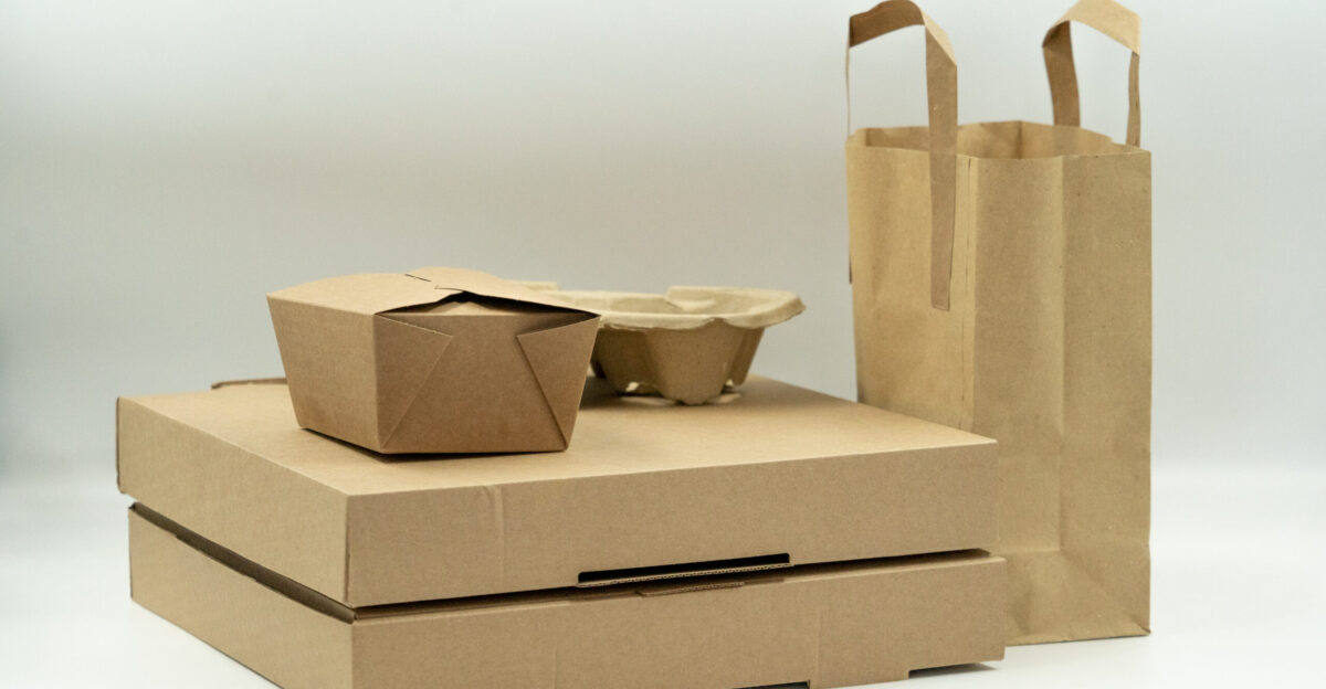 An image of two large cardboard boxes against a white background with a small box and a drinks carrier sitting on top of them A paper bag is standing beside them This picture was taken for use on our website meanwell-packaging co uk but has now been released for free use under Creative Commons