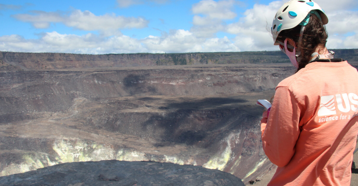 A Hawaiian Volcano Observatory (HVO) geologist notes observations of the active lava lake in Halema‘uma‘u crater, at the summit of Kīlauea. HVO scientists continue to monitor the ongoing eruption from an area within Hawai‘i Volcanoes National Park that remains closed to the public due to hazardous conditions. USGS photo taken by N. Deligne on October 5, 2021.