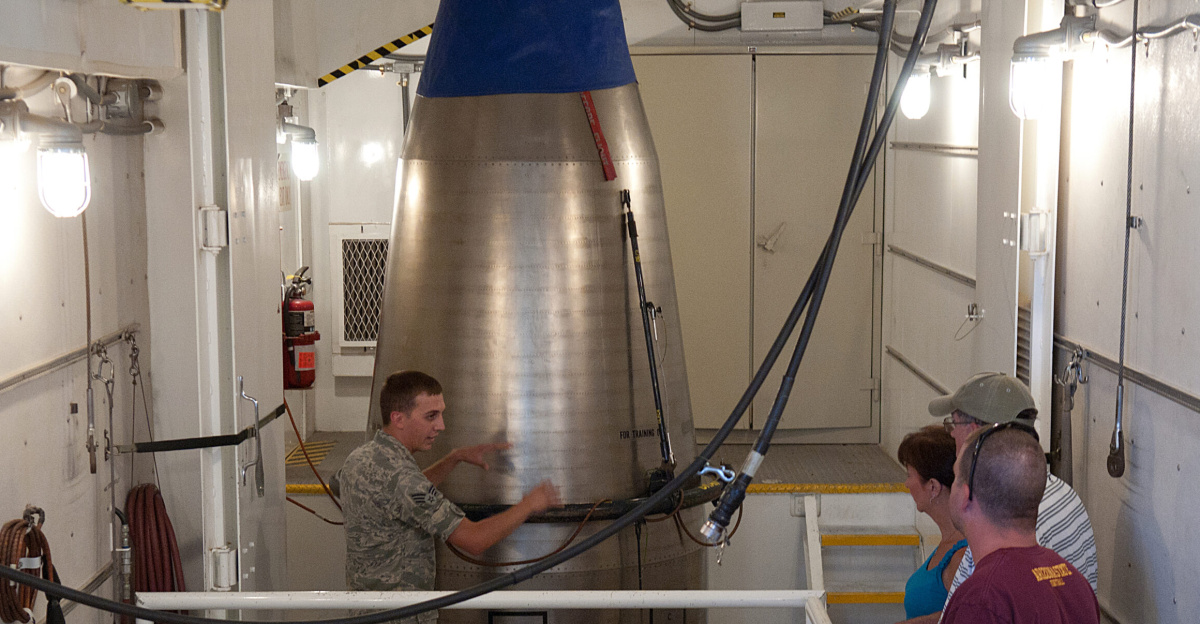 Senior Airman Nicholas Kolja, 90th Missile Operations Squadron, explains how the top stage of a Minuteman III missile is handled and then lowered out of a payload transporter to members of the public during a tour of ICBM training facilities on F.E. Warren AFB, Wyo. July 22, 2012. The tours were part of the base's open house during Fort D.A. Russell Days, an annual event which coincides with Cheyenne Frontier Days. (U.S. Air Force photo by R.J. Oriez/Released)