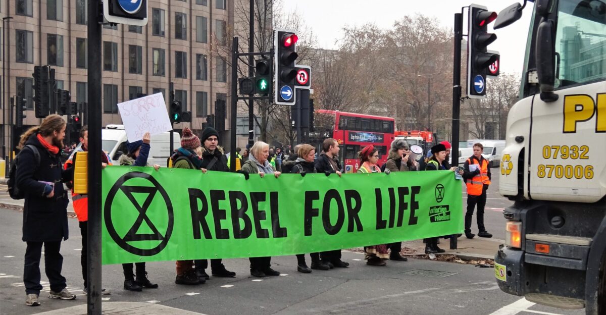 Extinction Rebellion swarming roadblocks with banner Rebel for life