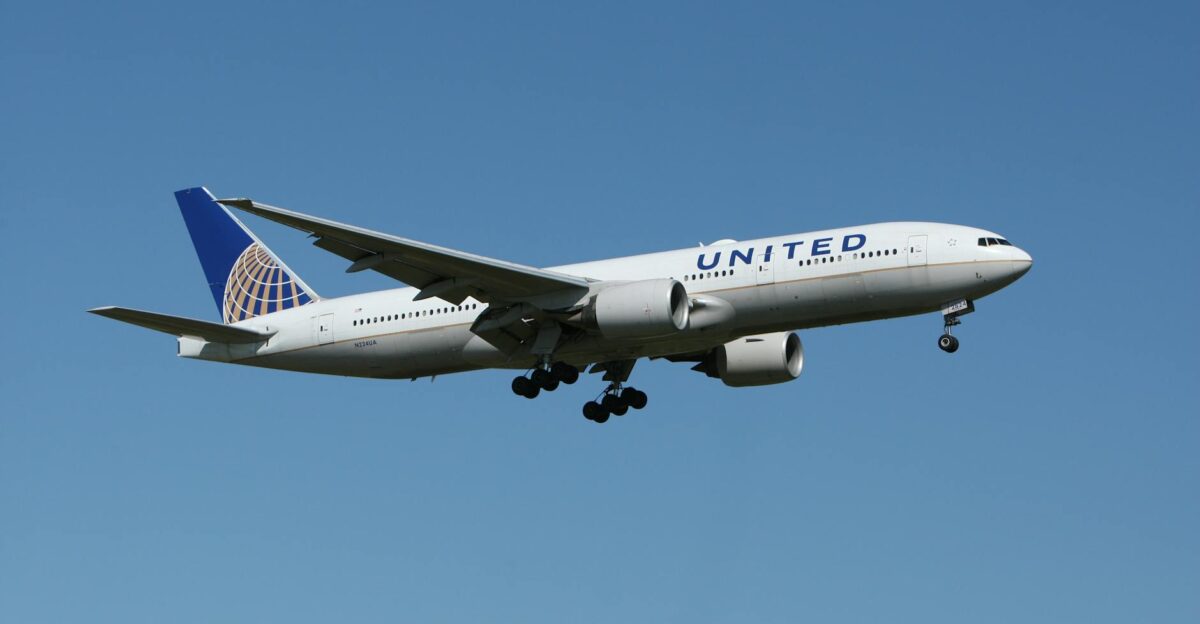 A United airliner flying against a clear blue sky showcasing air travel