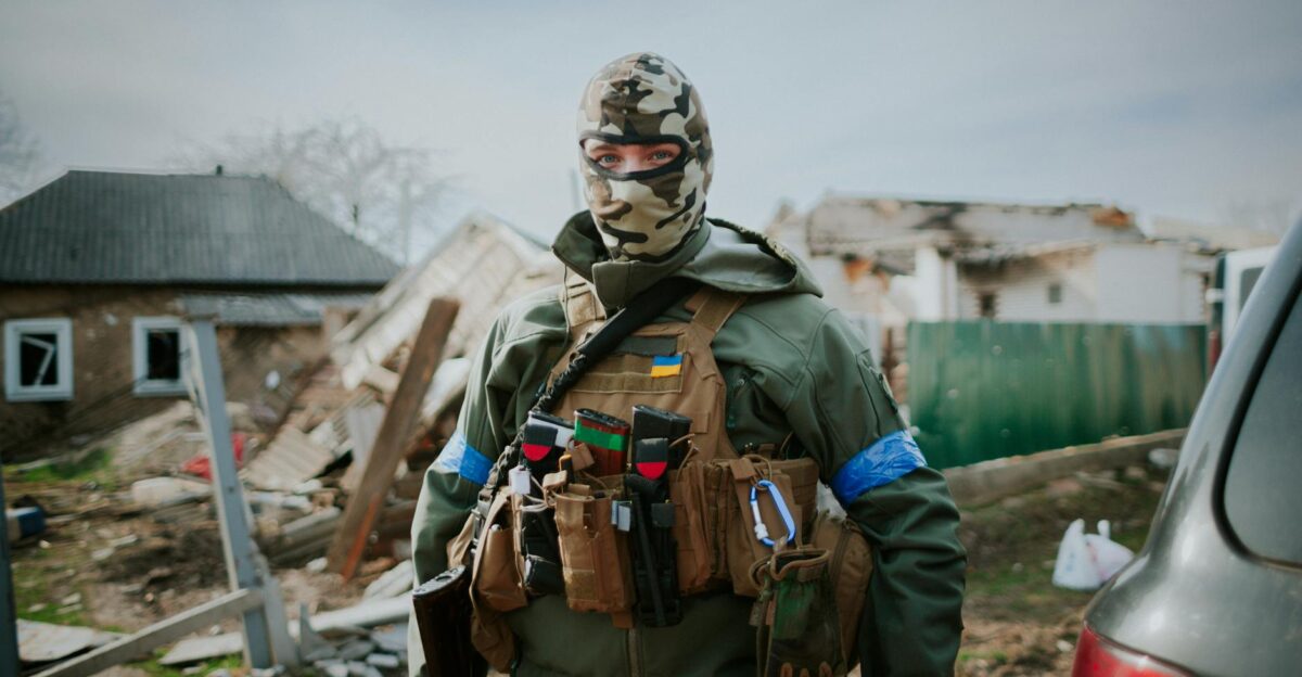 Soldier in camouflage gear standing in Kyiv Oblast Ukraine amidst destruction