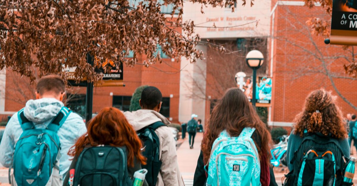 A group of college students with backpacks walking together outdoors on campus