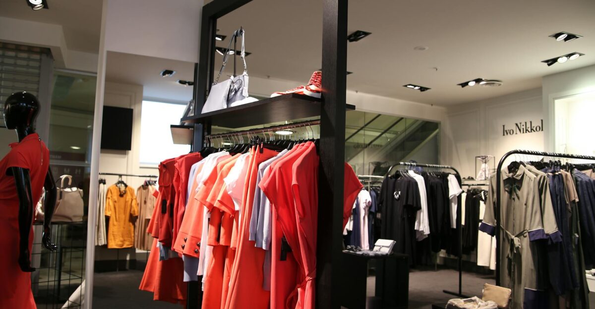 Discover a chic fashion boutique showcasing a variety of colorful clothes on elegant racks