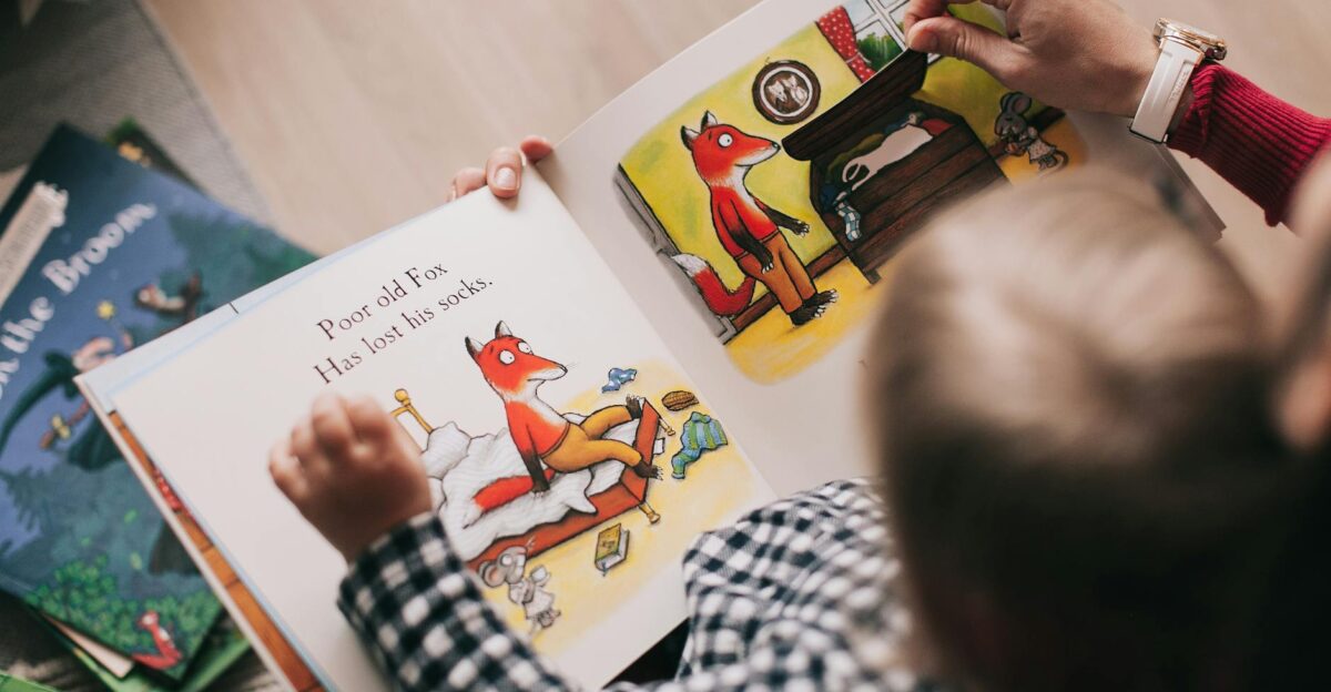 A child and adult reading an illustrated storybook together in a cozy setting