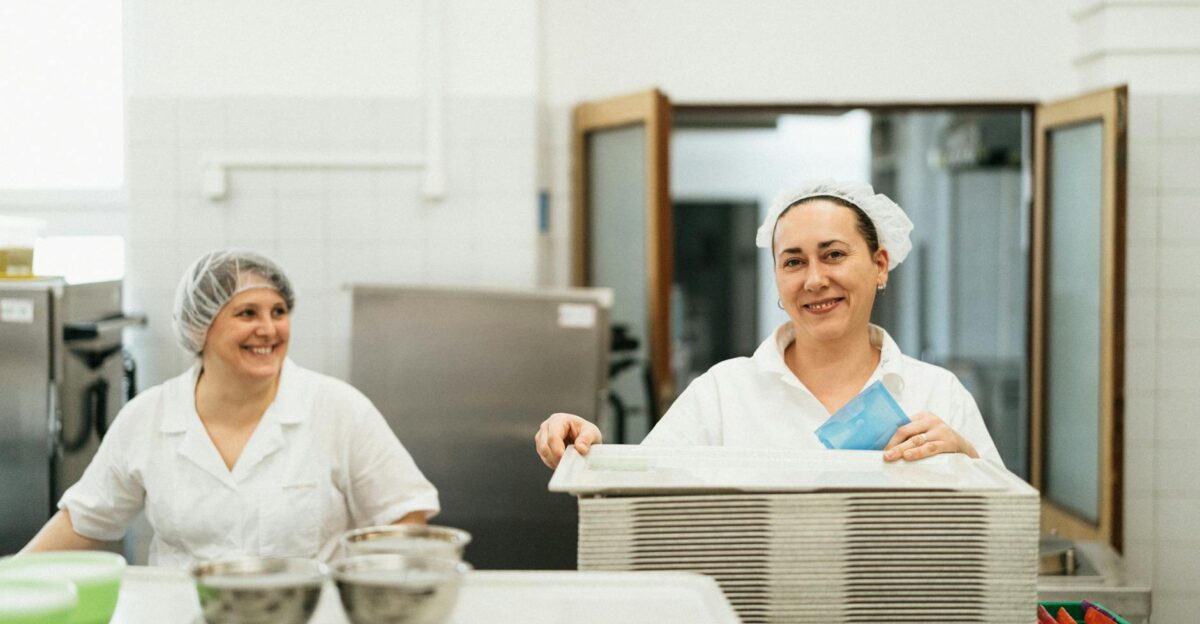 Friendly cafeteria staff working together in a kitchen showcasing teamwork and service