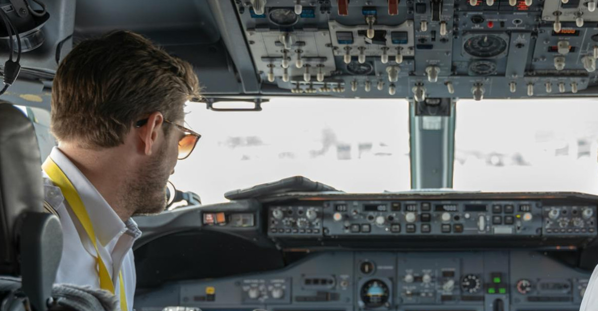 Two pilots navigating an aircraft cockpit focused on advanced avionics and flight systems