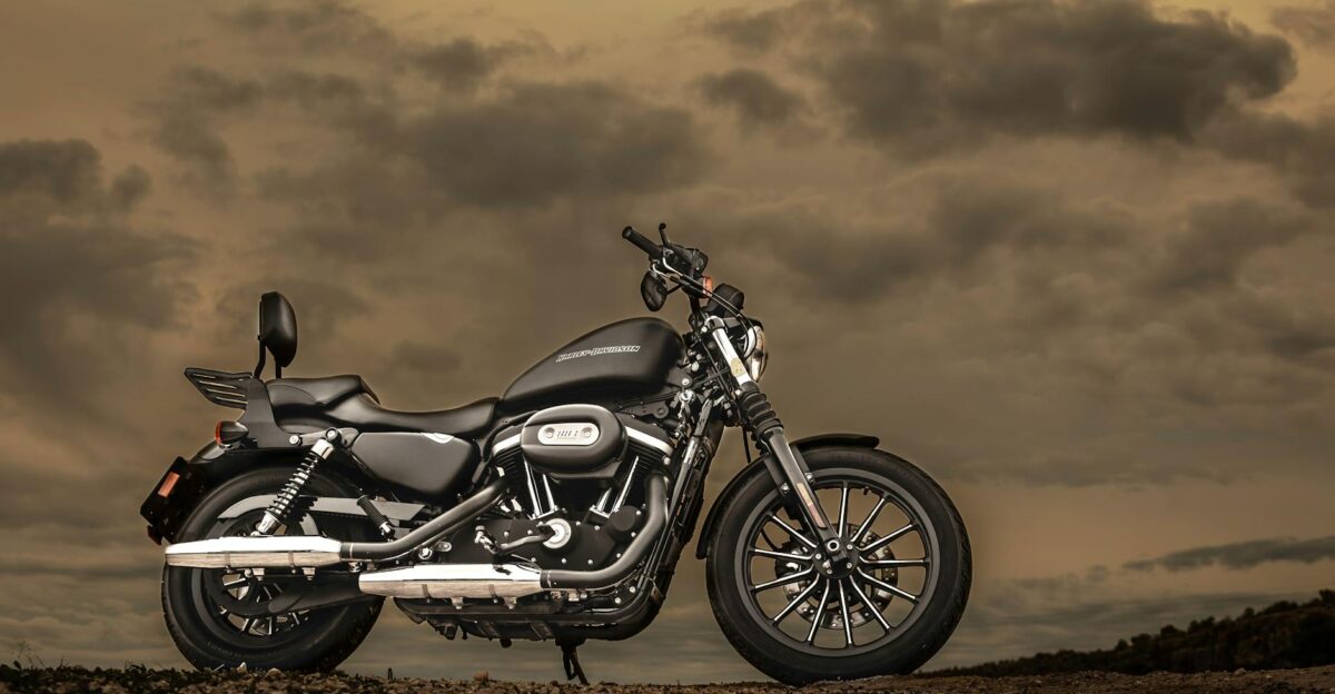 Harley Davidson motorcycle parked outdoors against a dramatic sunset sky showcasing elegance and freedom