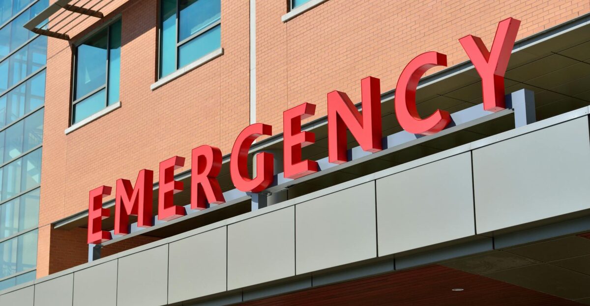 Close-up of a modern hospital emergency room entrance with prominent red letters