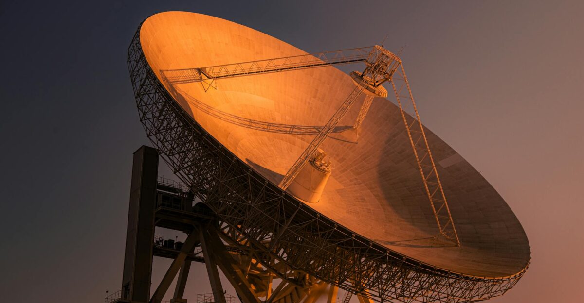 A striking satellite dish basking in golden hour light capturing signals from space