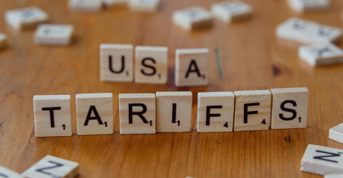 Wooden tiles spelling USA and TARIFFS on a wooden surface symbolizing trade issues