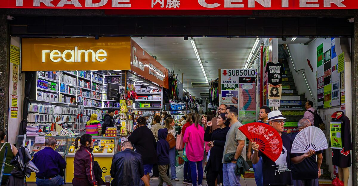 Crowded trade center with diverse shoppers and colorful market stalls bustling with activity