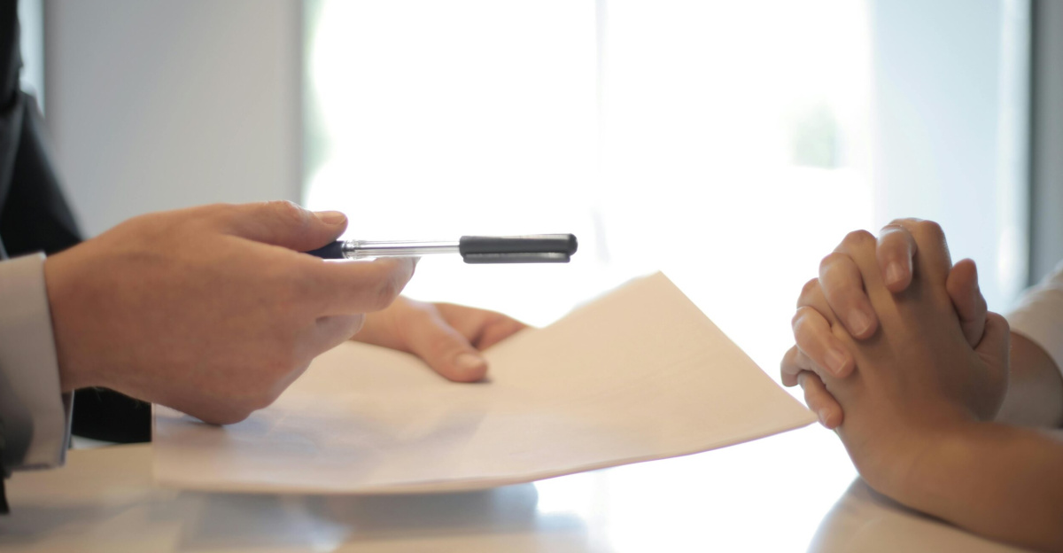 Close-up of a contract signing with hands over documents. Professional business interaction.