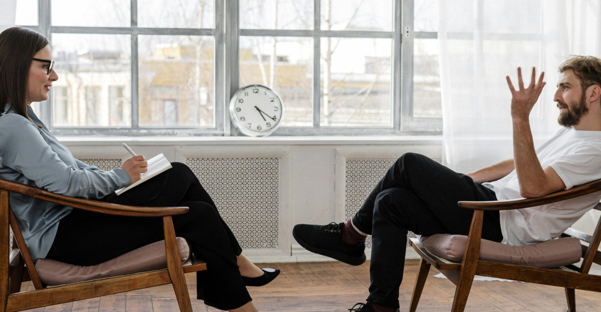 A therapist engaging in a counseling session with a male patient to support mental health.