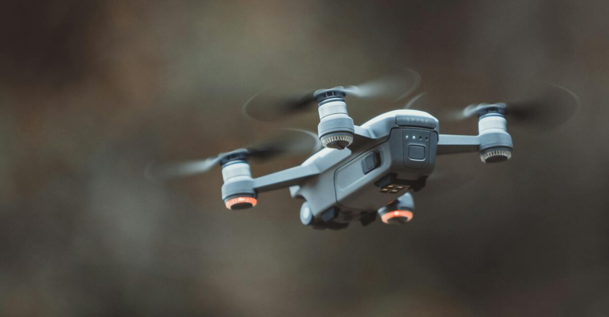 A detailed close-up of a drone flying in an outdoor setting showcasing its design and technology
