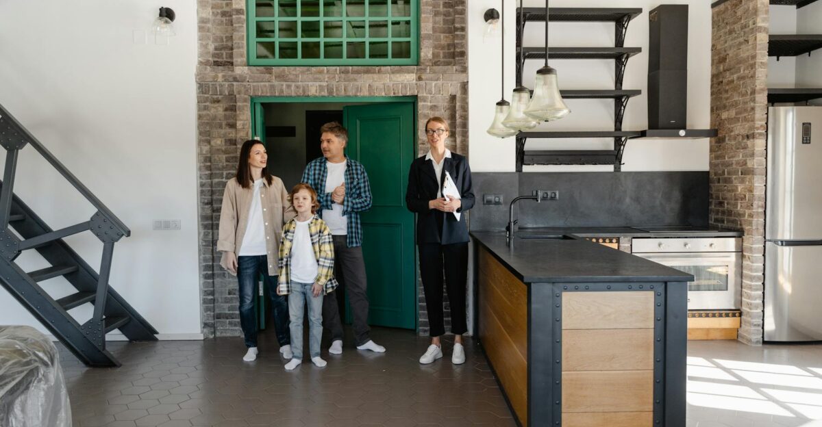 A family with a realtor viewing a modern industrial-style kitchen in a new home