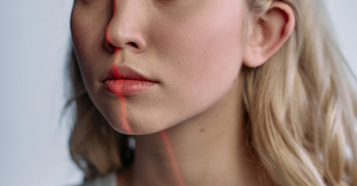 Blonde woman with red laser line on face depicting futuristic facial recognition technology