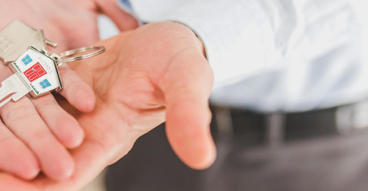 Close-up of a couple holding keys symbolizing homeownership and investment
