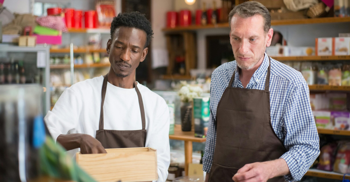 Two male employees organizing products in a cozy grocery store.