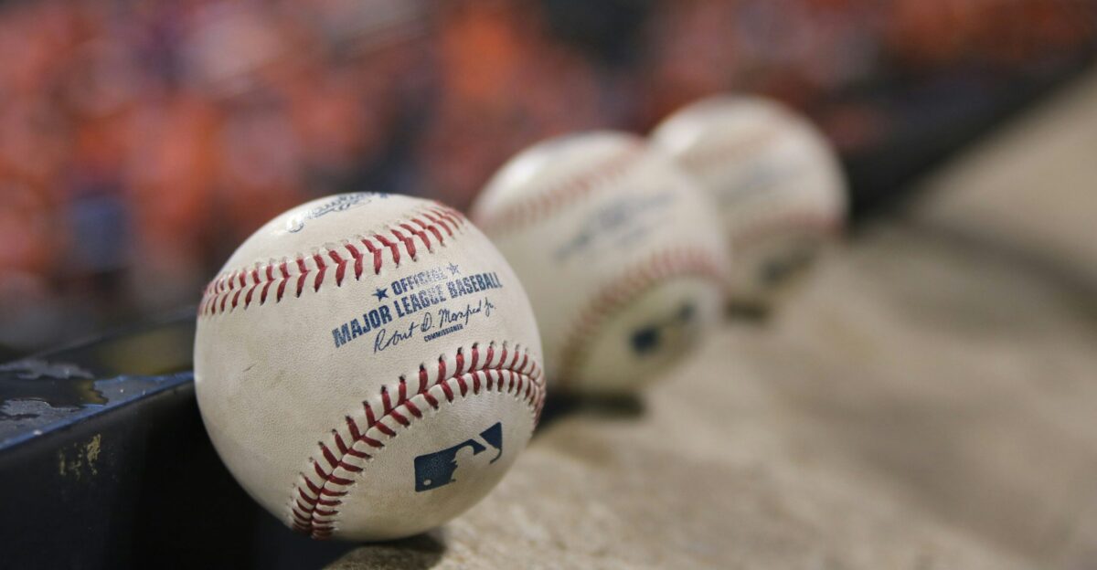three white baseballs on gray textile