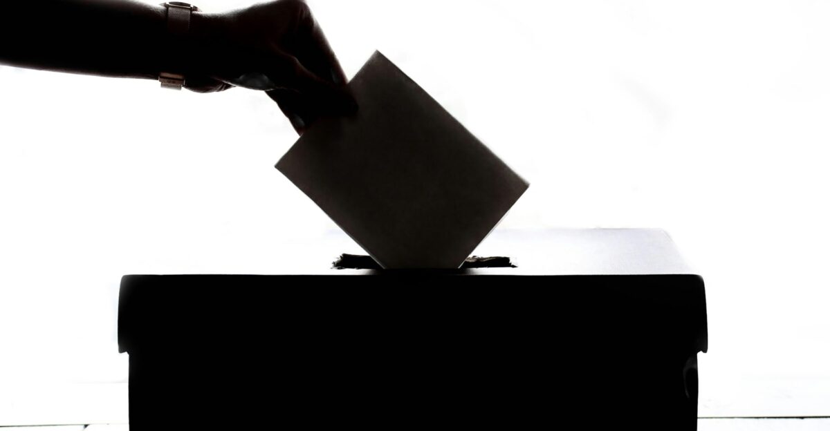 a person is casting a vote into a box