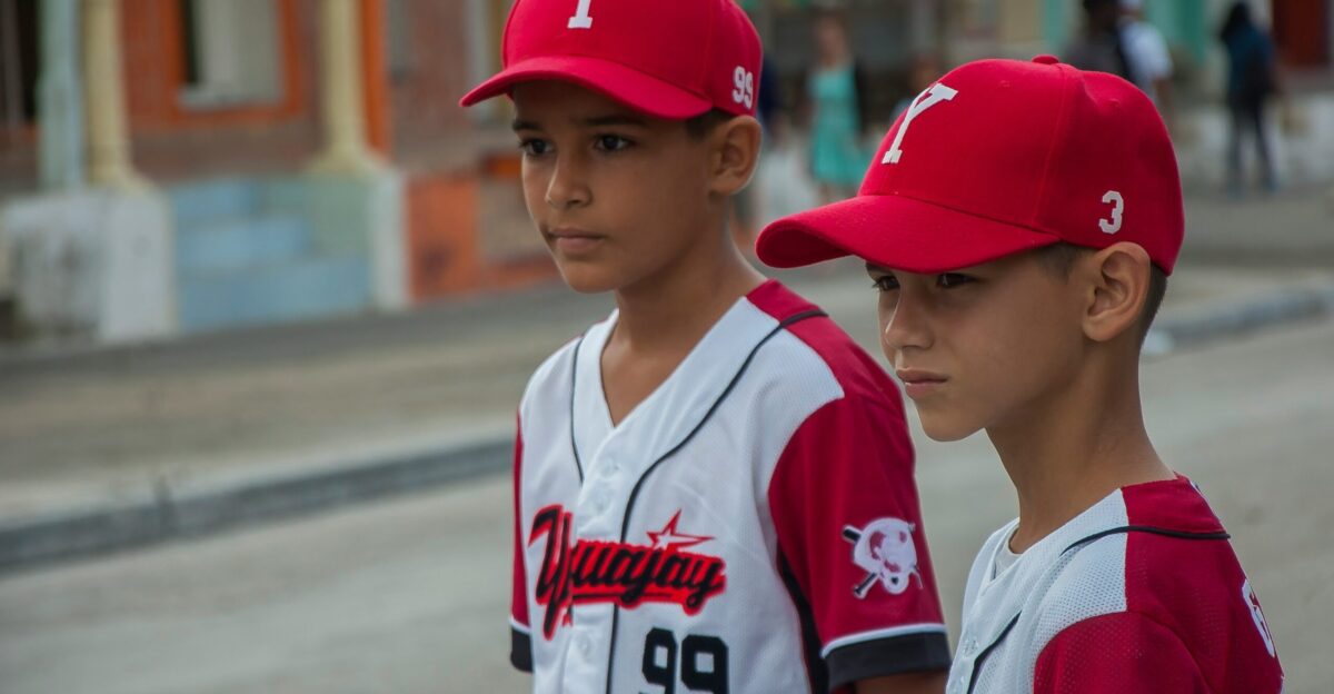 two boys wearing baseball uniform during day