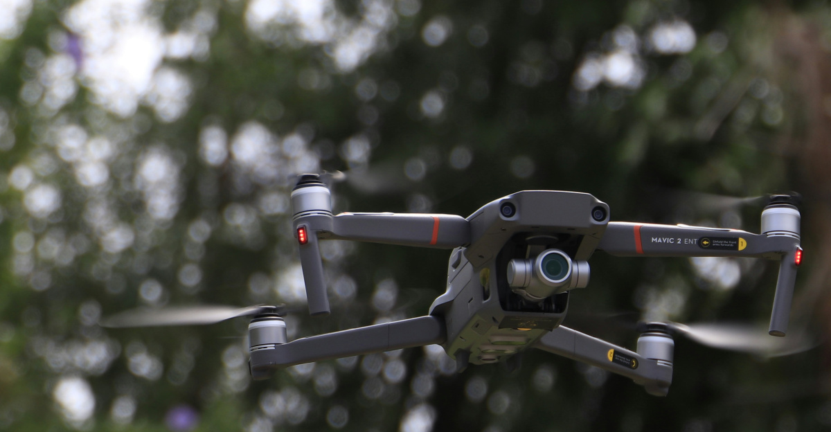 black and white drone flying in mid air during daytime