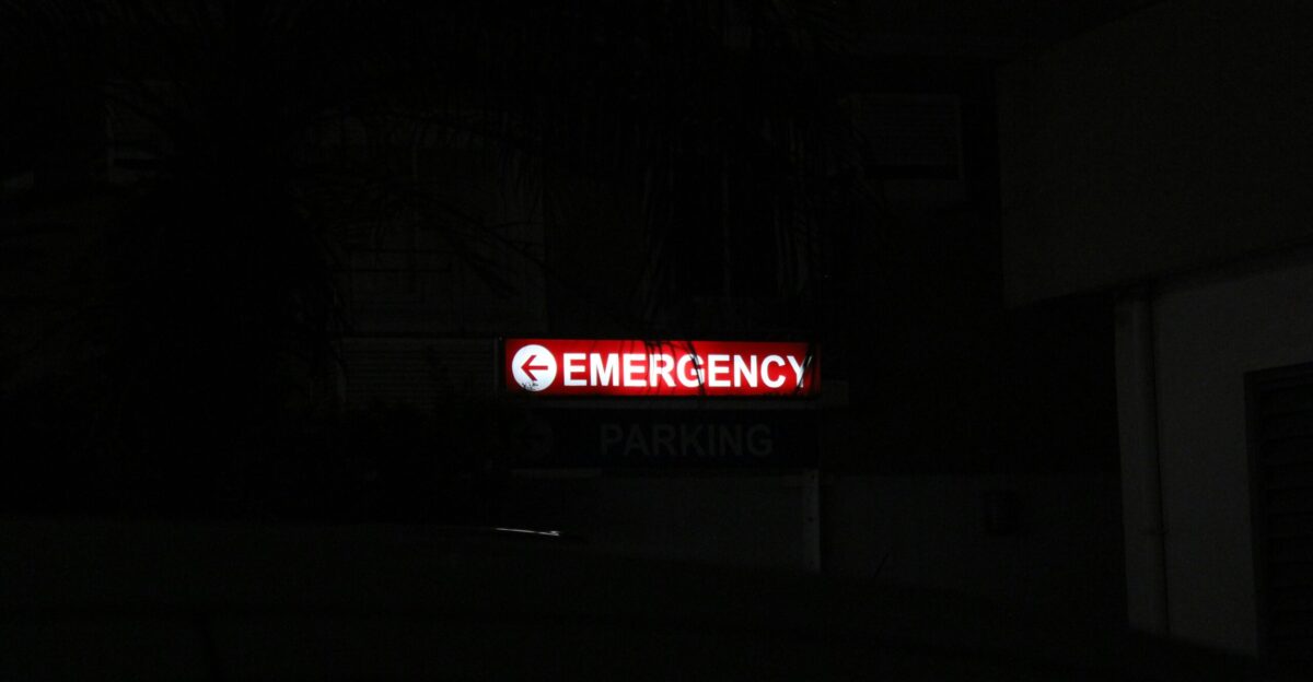 a red emergency sign lit up in the dark