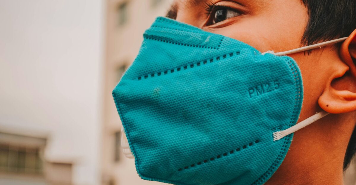 woman in blue tank top covering her face with blue textile