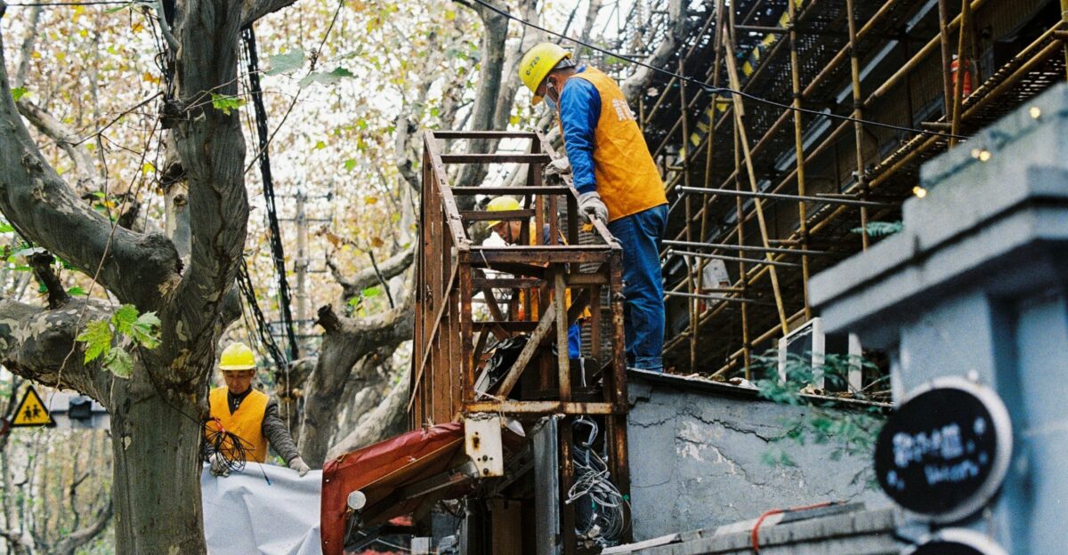 man in yellow hard hat and white long sleeve shirt climbing on ladder