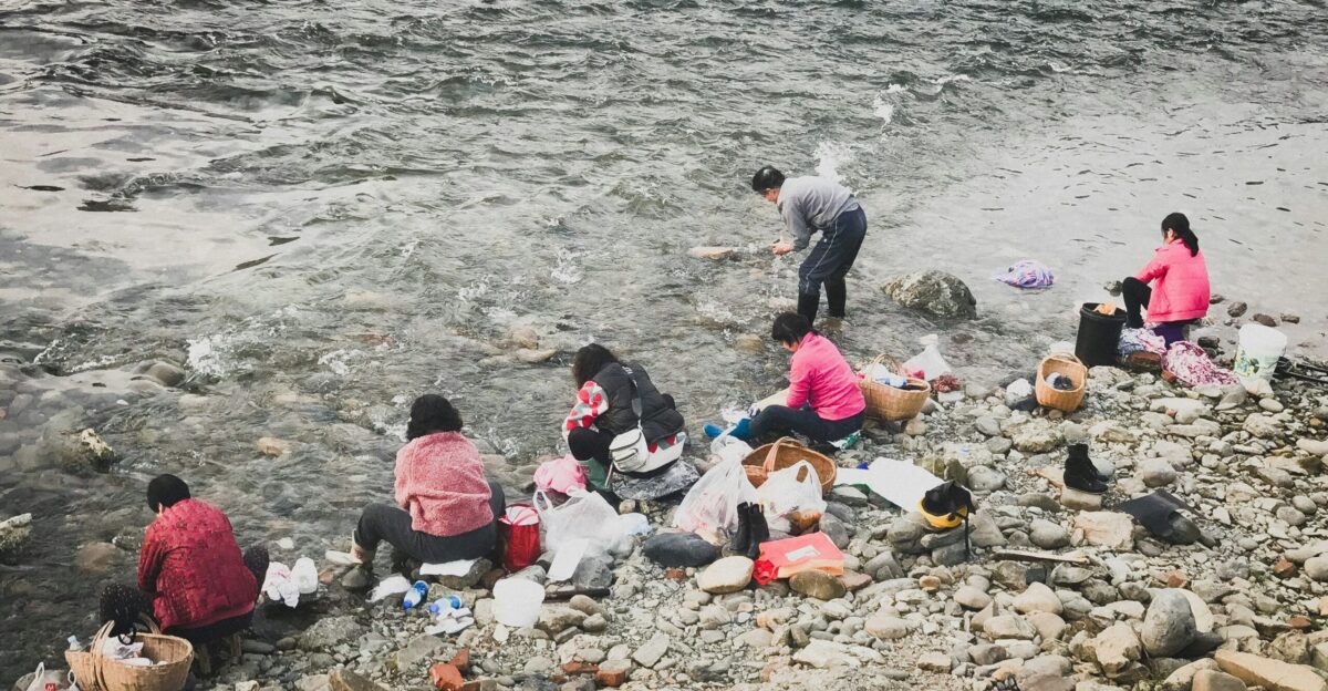 people sitting on rocky shore during daytime