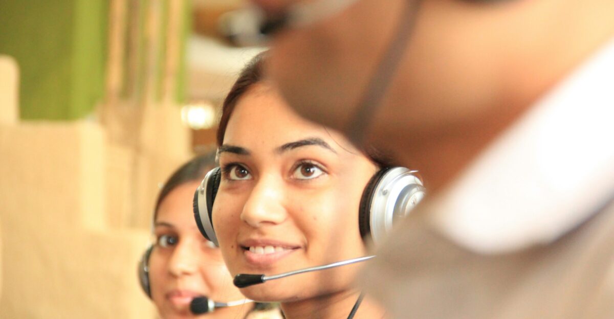 woman in black headphones holding black and silver headphones