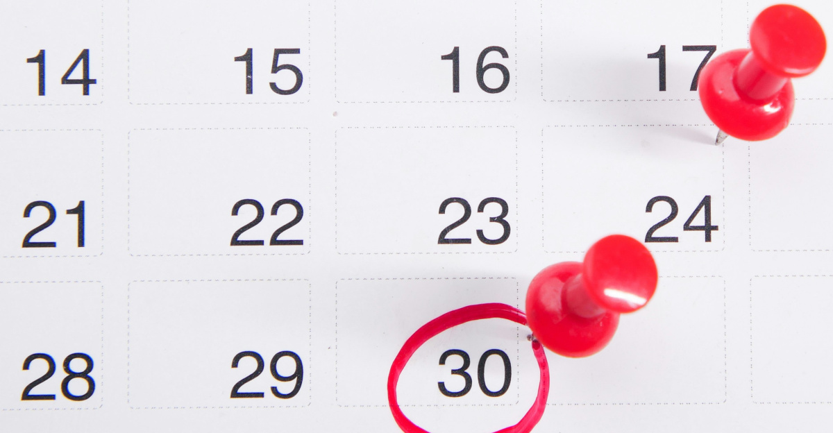 a calendar with red push buttons pinned to it