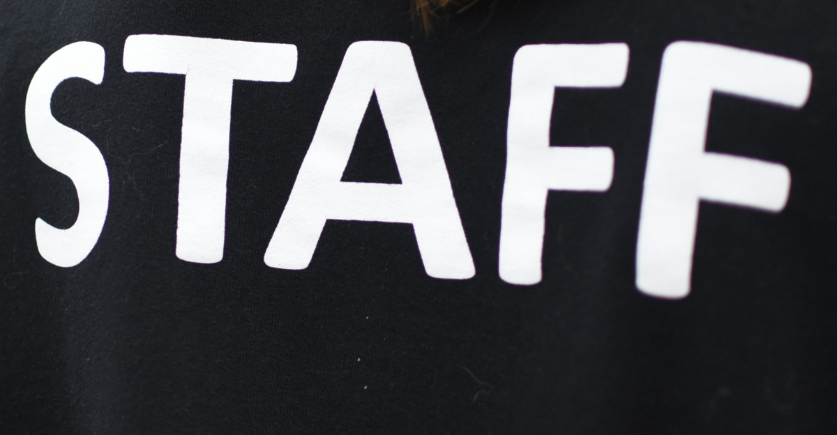 a person wearing a black shirt that says staff
