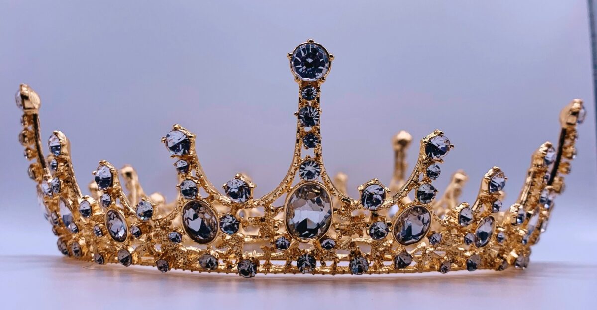 a gold crown with black and white stones