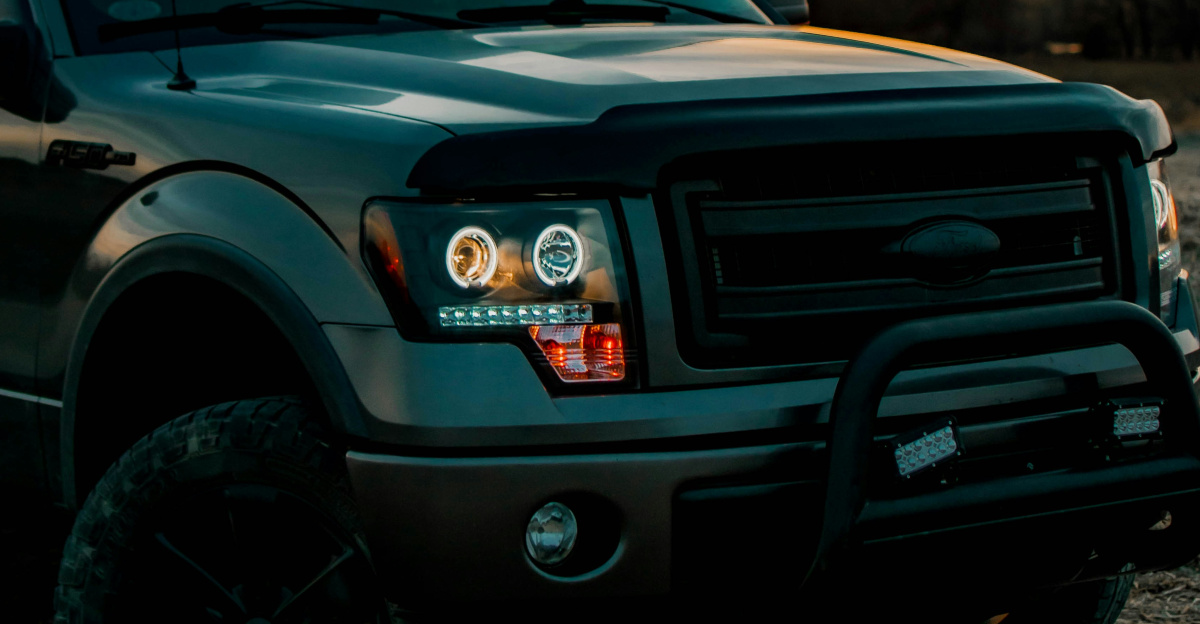 a pickup truck parked in a field at sunset